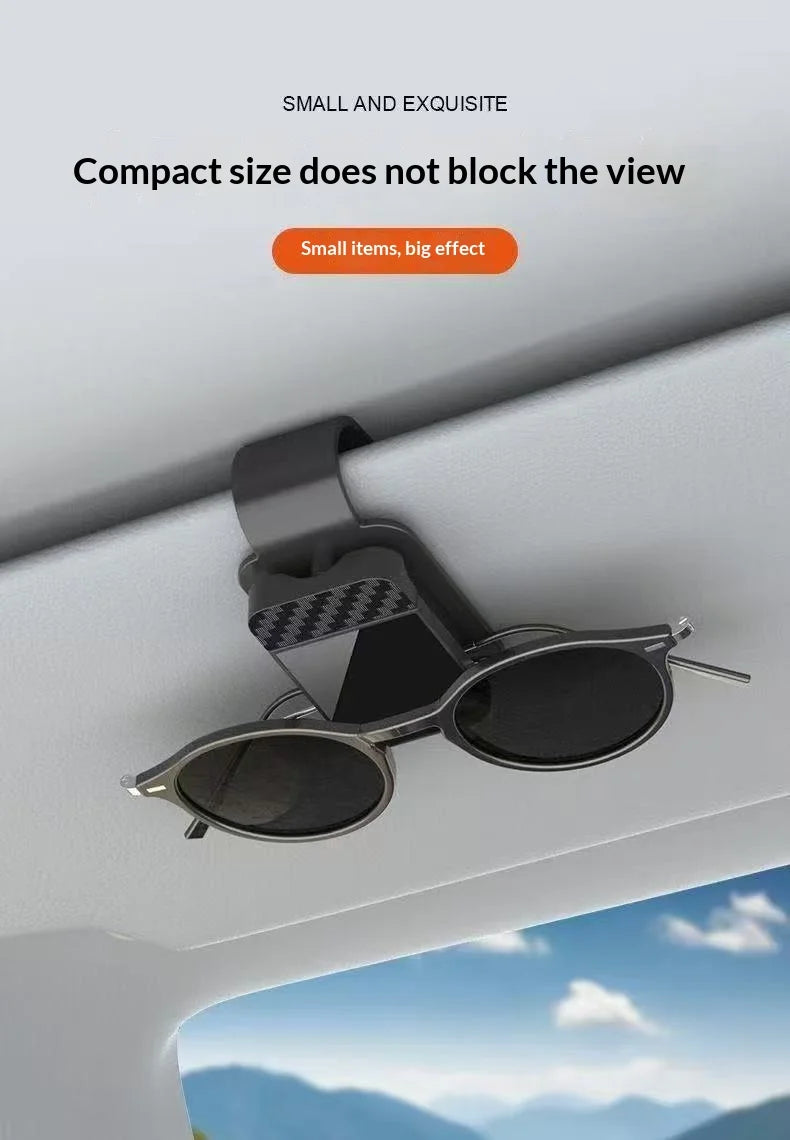 A pair of sunglasses is displayed on a magnetic holder mounted on a car window frame.