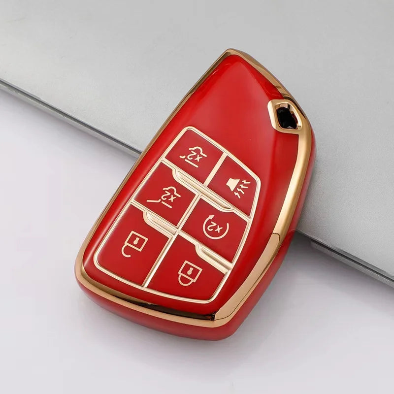 A red and gold durable TPU car key fob cover with various buttons shown on a gray background.