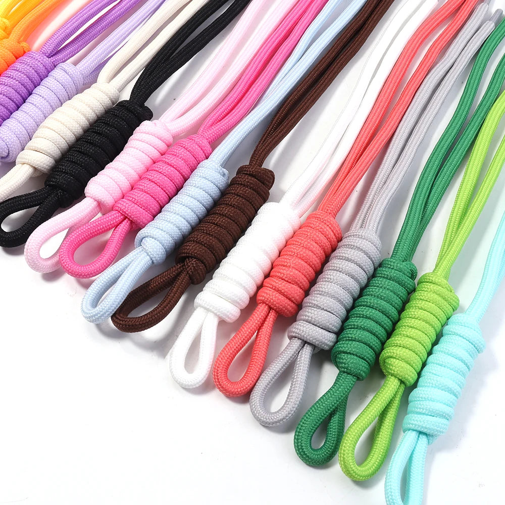 A variety of colorful braided nylon lanyards in shades of pink, purple, black, white, and green are displayed.