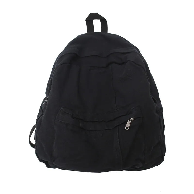 Black canvas patchwork backpack with a top handle and zippered pocket