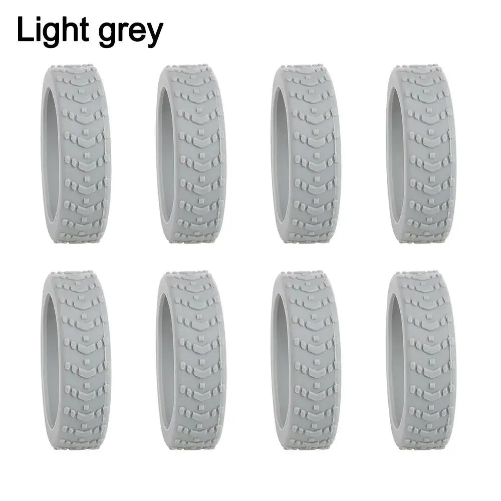 A set of light grey silicone luggage wheel protectors designed to prevent scratching and reduce noise during travel.