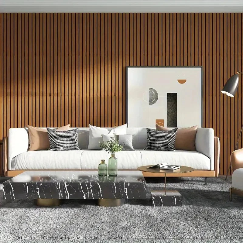 A modern living room featuring a light sofa, dark marble coffee table, and a large framed artwork against a vertical wood pan