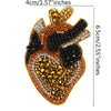A large, ornate patch made of sparkling gold and black beads and rhinestones for clothing or crafts.