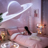 A pink bedroom scene featuring a galaxy projection light and a person relaxing on a bed.