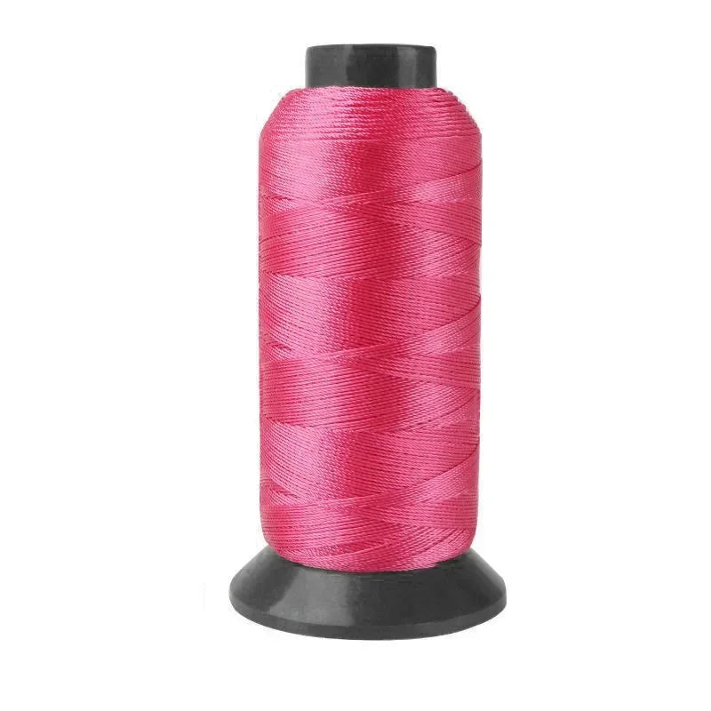 A spool of bright pink heavy-duty nylon sewing thread for upholstery and denim.