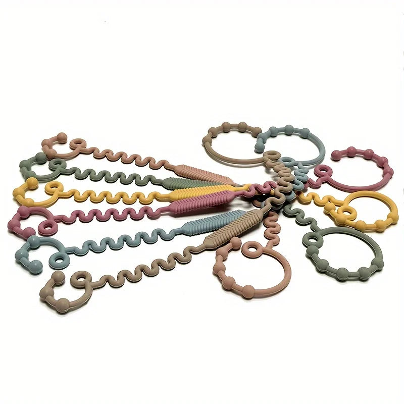 A collection of silicone anti-drop pacifier clips and teethers in various pastel colors like green, yellow, pink, and blue.