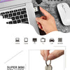 A hand holds a mini USB disk next to a laptop and various electronic devices.