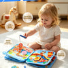 A baby is playing with a multi-play busy book featuring marine animals and various toys.