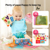A baby is playing with a cloth book toy and various colored silk scarves and sound paper.