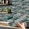 A hand places peel-and-stick tile stickers featuring blue and gray marble patterns onto a kitchen backsplash.
