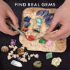 Hands excavating colorful gemstones and crystals from a piece of rock.
