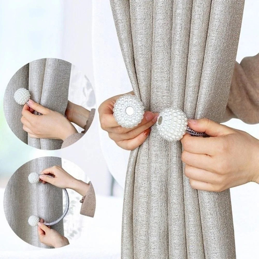 Hands are shown using pearl magnetic curtain clips to hold a gray fabric curtain.