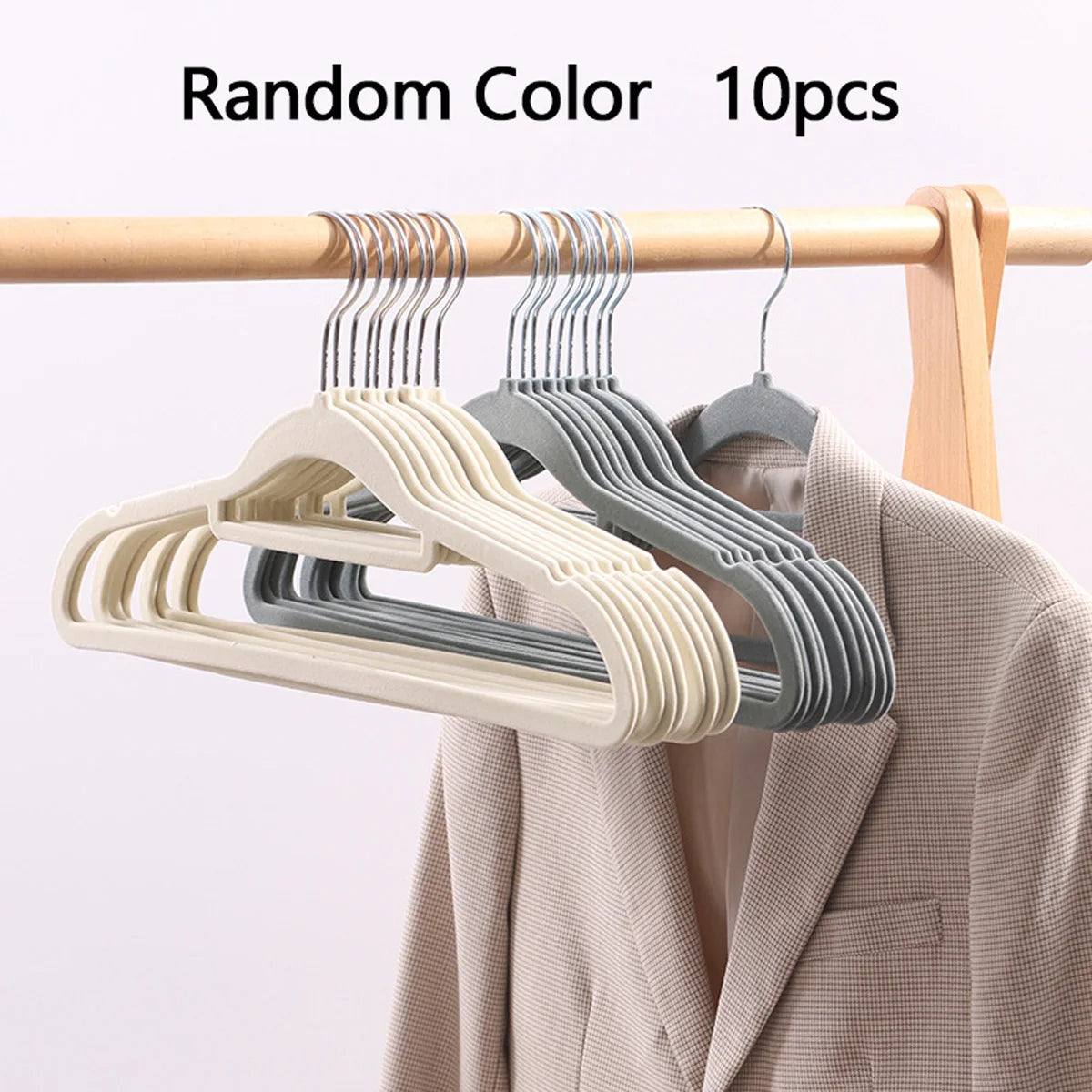 Ten random color velvet non-slip hangers hanging on a wooden rod next to a coat.