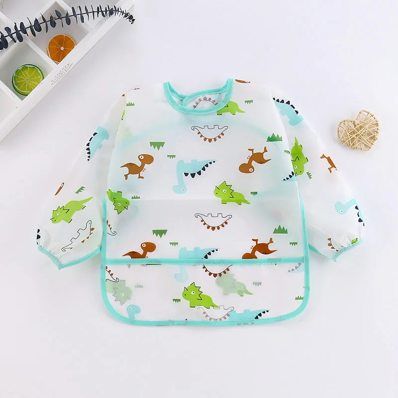 A clear waterproof long sleeve art smock and feeding bib featuring colorful dinosaur and nature patterns.
