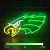 A neon sign shaped like an eagle in bright green and yellow outlines against a dark background.