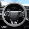 A grey soft silicone steering wheel cover installed on a car's steering wheel.