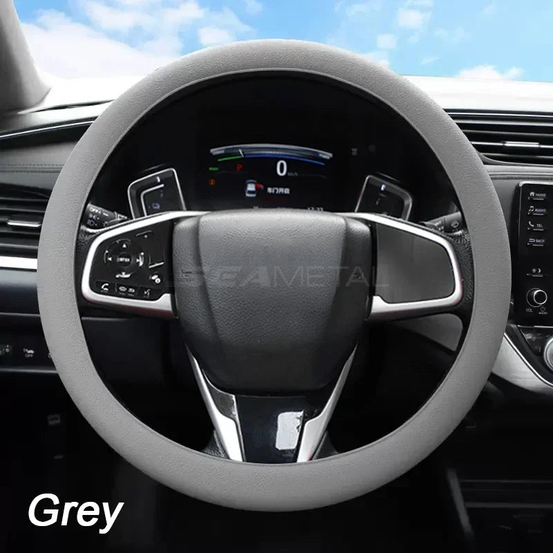 A grey soft silicone steering wheel cover installed on a car's steering wheel.