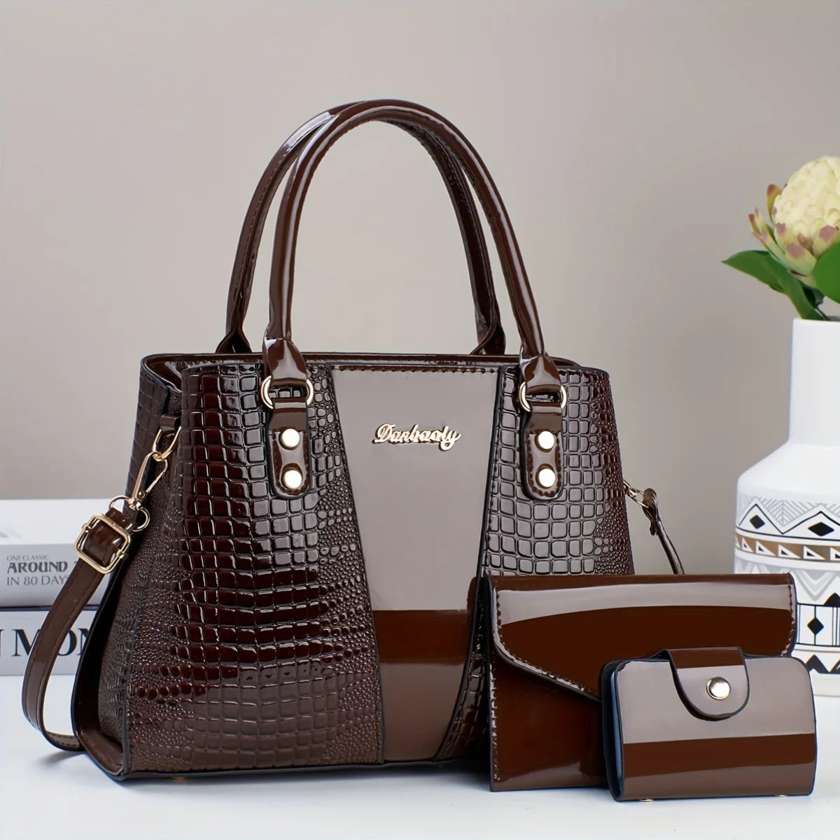 Braunes Krokodilmuster-Patentlederhandtaschenset mit Klappe und Clutch.