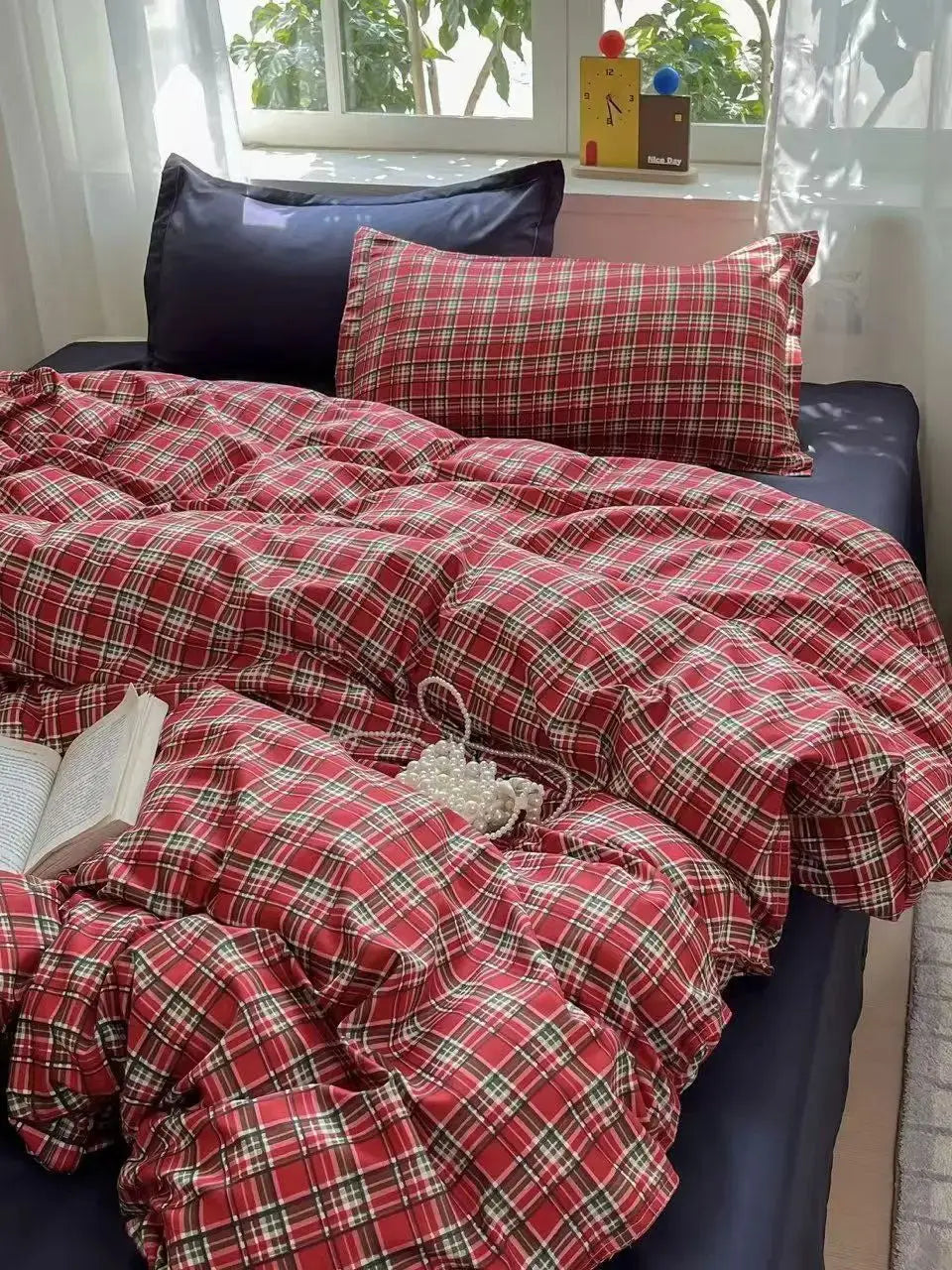 A red and black plaid bedding set featuring a duvet cover, flat sheet, and pillowcases displayed on a bed.
