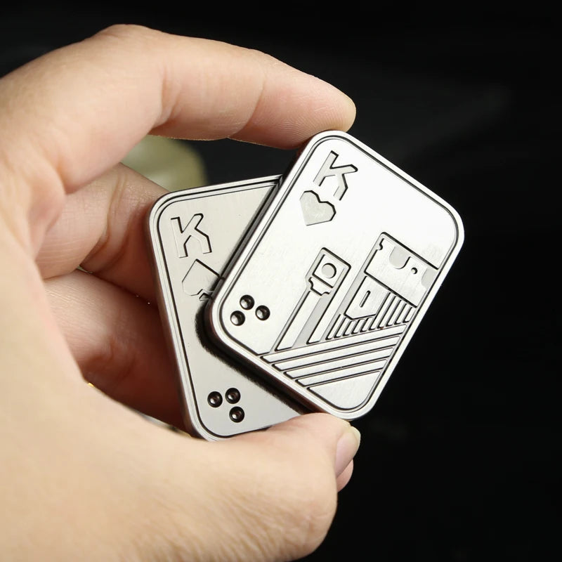A hand holds a metal fidget slider toy with card designs on it.