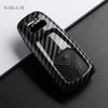 A black carbon fiber style key fob cover for an Audi, shown in a close-up view.