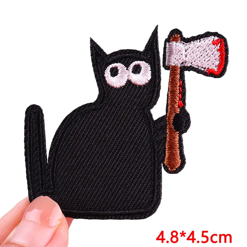 Black embroidered iron-on patch of a cat holding a wooden hammer