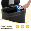 A hand is opening a black automatic touchless trash can, demonstrating its smart sensor quick-opening feature.
