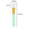 A silicone facial mask brush with a white tapered head and an orange handle, shown next to dimension lines.