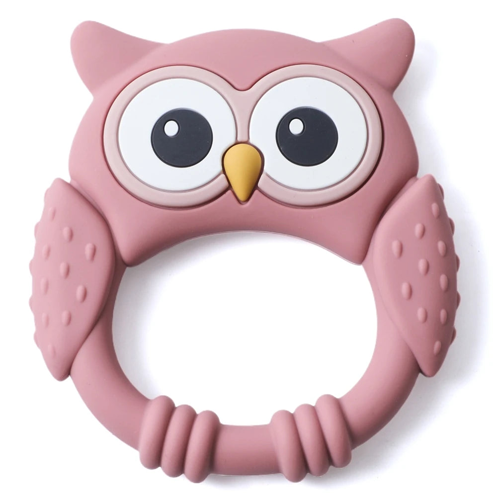A pink owl-shaped silicone teether and rattle for babies with large eyes and rounded features.