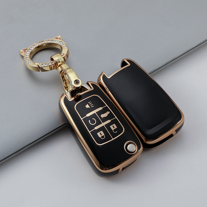 A gold-toned key fob cover with a keyring and a black protective case featuring buttons.