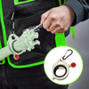 A hand is clipping a glow-in-the-dark cable tie organizer with a carabiner onto a black tactical vest.