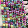 A close-up of multicolored natural stone square faceted beads in various shades of pink, green, yellow, and purple.