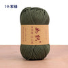 A ball of dark olive green 19-ply crochet yarn with a brown label is shown on a wooden surface.
