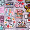 A collection of embroidered iron-on patches featuring various phrases and designs on a light gray background.