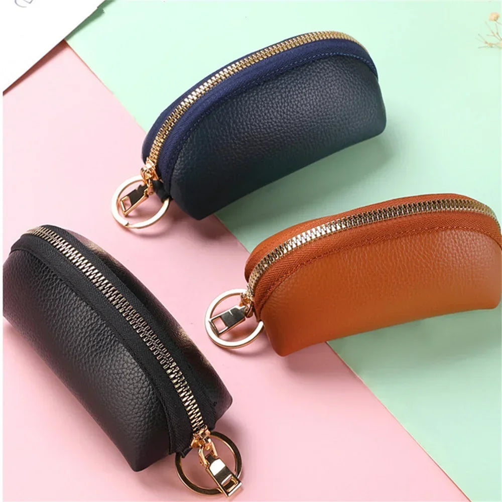 A set of three PU leather key organizer wallets in black, navy blue, and brown leather with gold-toned zippers