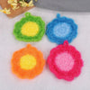 Four colorful acrylic non-stick dish sponges in green, blue, orange, and pink resting on a white surface.