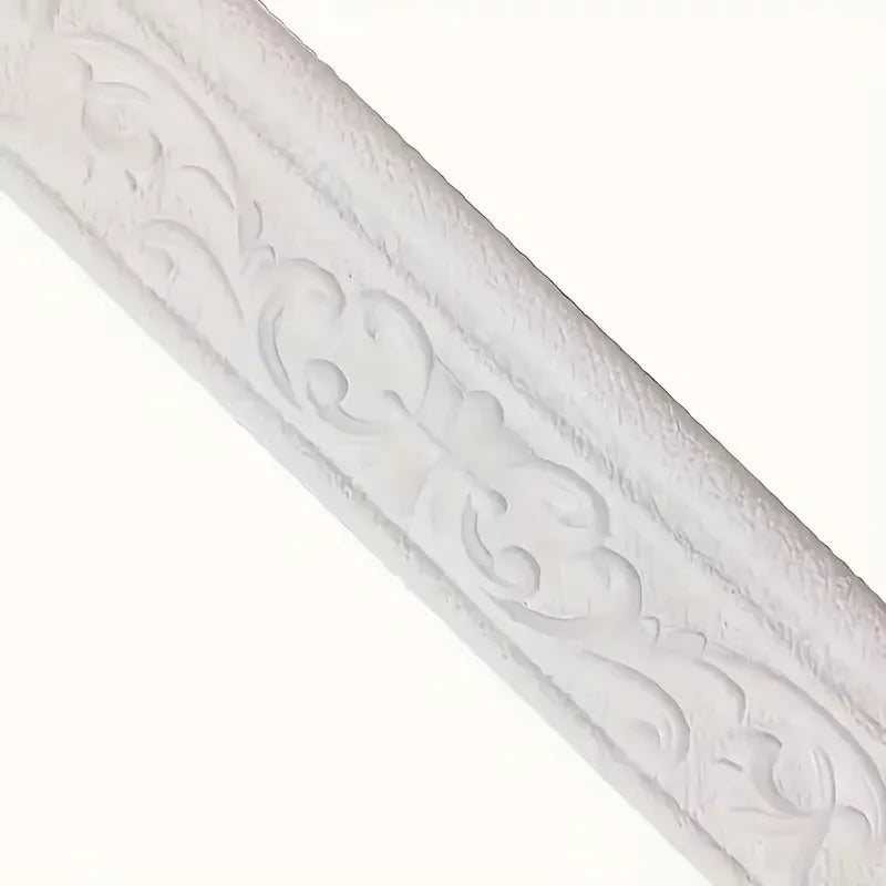 White 3D foam wall trim border sticker with decorative scrollwork applied to a surface.