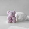 A pink silicone mold shaped like a fluffy bear hugging a rose, next to a white block.