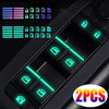 Close-up of glow-in-the-dark car window switch stickers and related components on a black device.