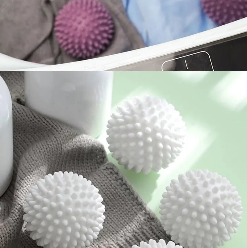 Close-up of white and pink reusable laundry balls on a gray knitted fabric.