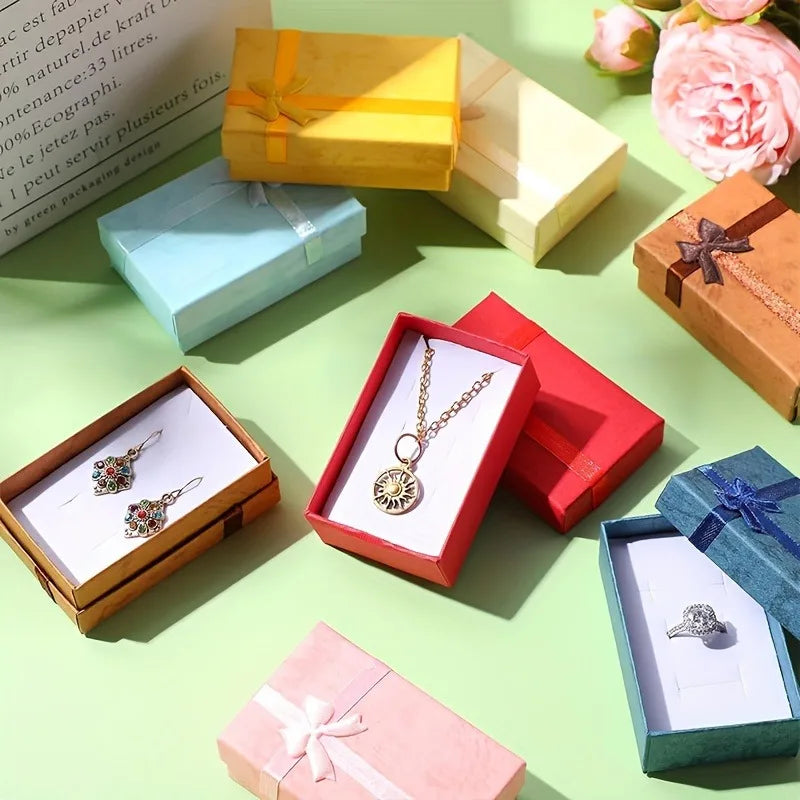 Assorted velvet jewelry gift boxes in yellow, pink, and blue with cushioned inserts