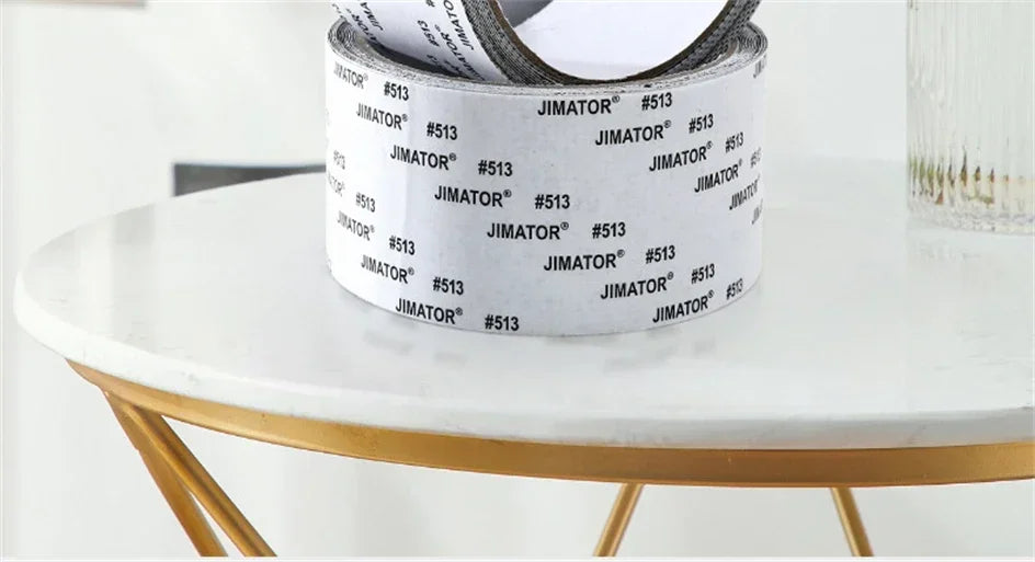 Roll of white Jimator self-adhesive fiberglass screen repair tape resting on a gold-rimmed table.