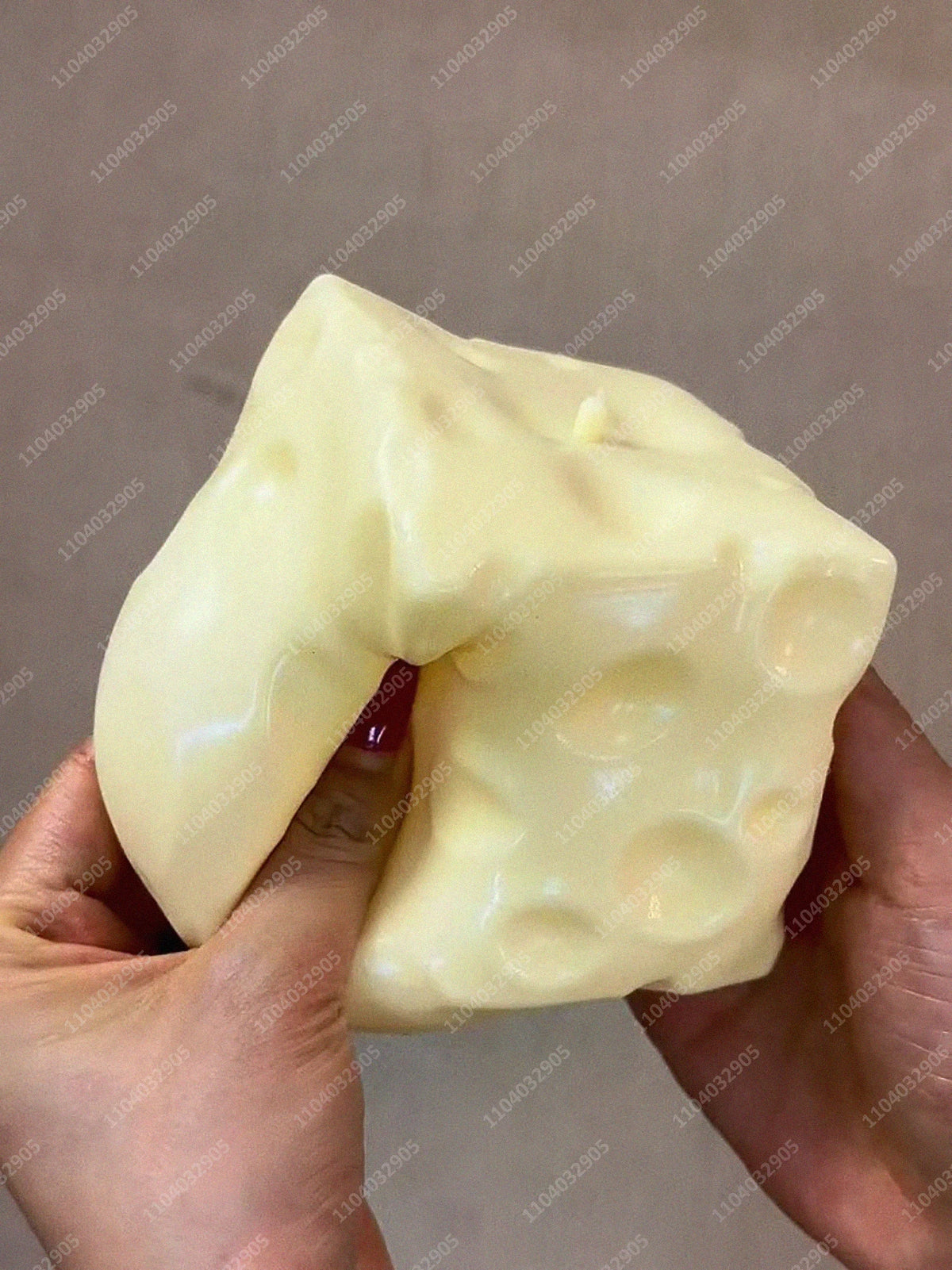 Eine Hand presst einen großen, blassgelben Stressball-Fidget-Spielzeug.