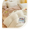 A cozy milk velvet bedding set featuring a duvet cover, pillowcases, and a stuffed rabbit toy.