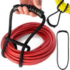 A hand is holding a black hook and loop storage strap, with coiled red straps and yellow straps visible.