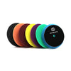 A row of professional foam polishing pads for car detailing in various colors including orange, purple, yellow, and blue.
