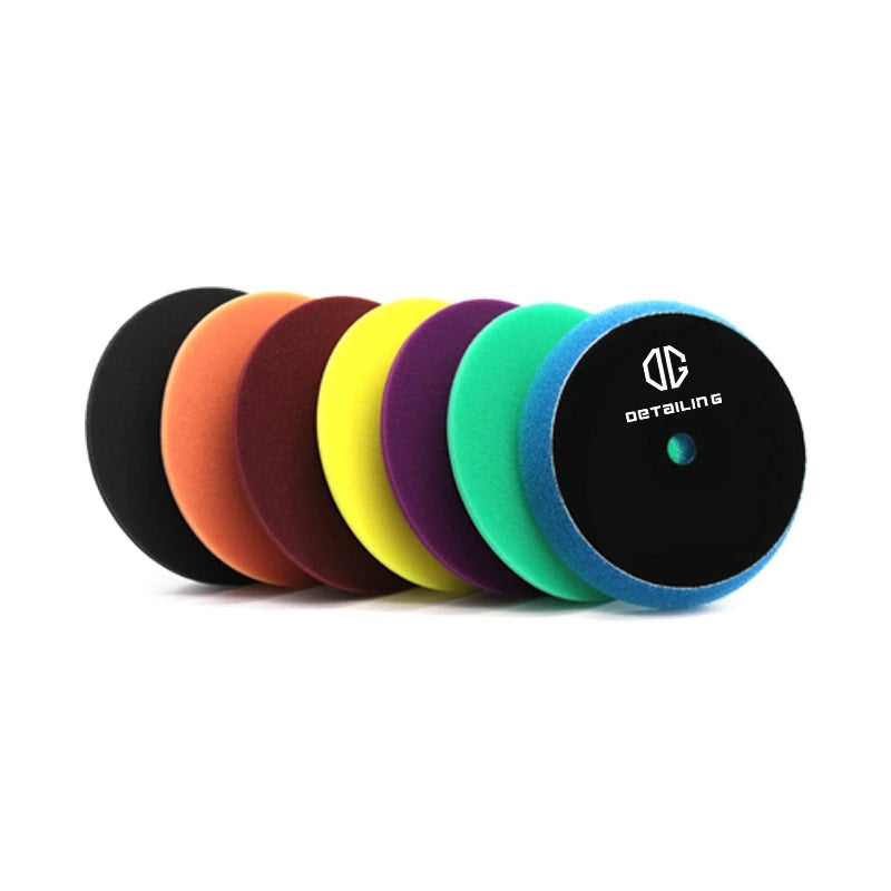 A row of professional foam polishing pads for car detailing in various colors including orange, purple, yellow, and blue.