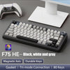 A black mechanical keyboard with white and gray keys is shown next to a wireless mouse and a white charging pad.