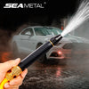 A hand holds an adjustable high-pressure car wash water gun spraying water onto a car in a dark setting.