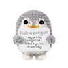 A gray crocheted penguin figurine holding a card with the text Positive penguin I may be a tiny penguin but I believe in you 